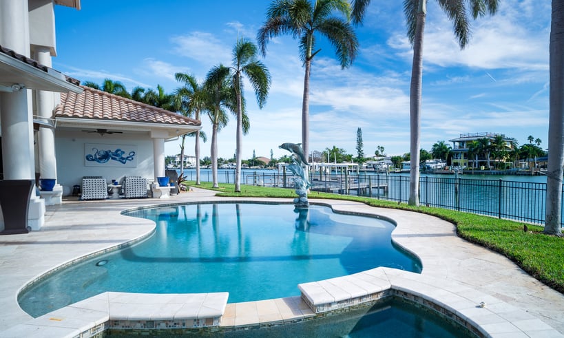 pool surrounded by palm trees near bay