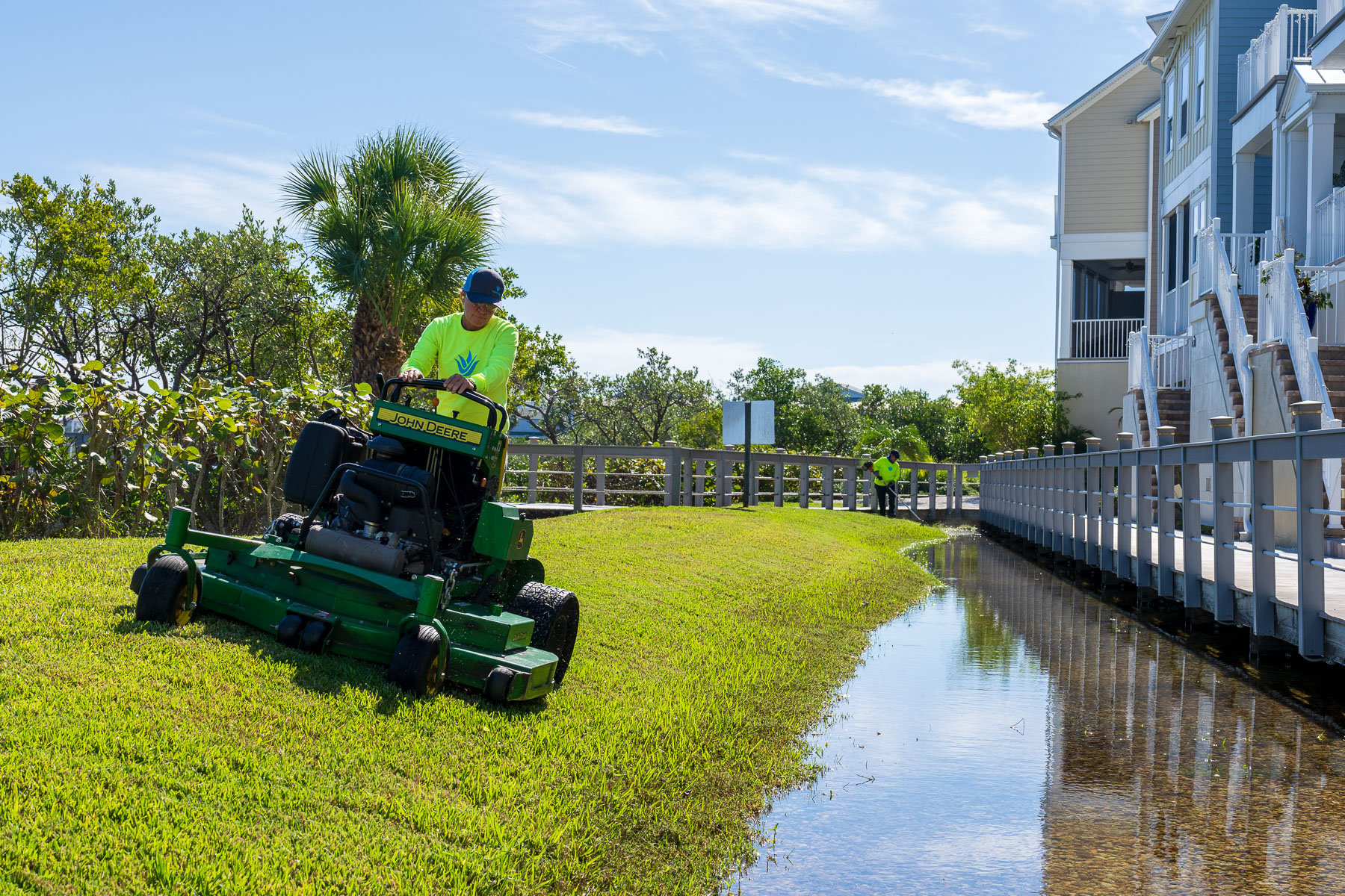 Landscape maintenance crew mowing along water 1