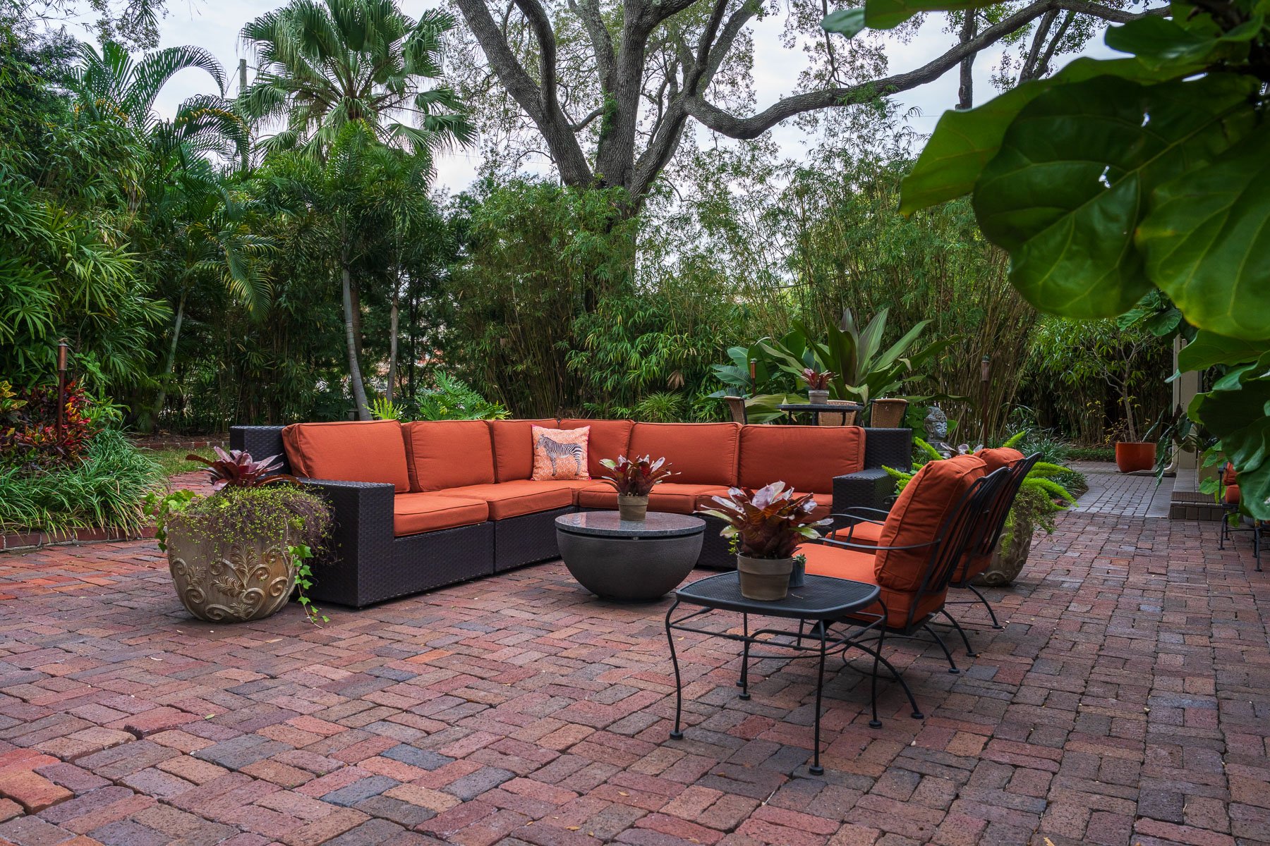 backyard patio with landscape beds and potted plants