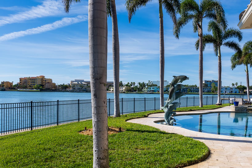 pool with palm trees and dolphin sculpture