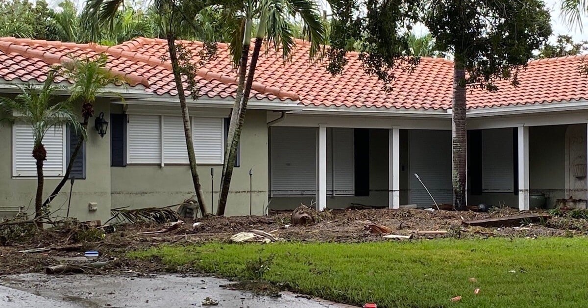 hurricane storm damage debirs in front of house cropped