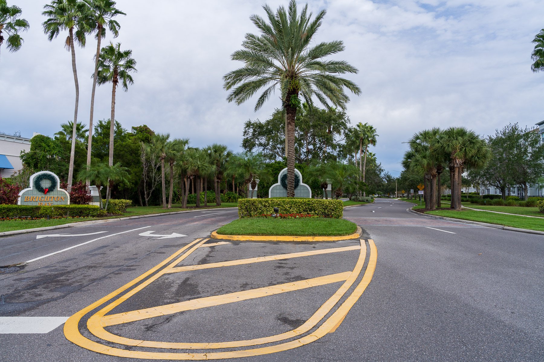 HOA entrance with landscape beds and large trees 